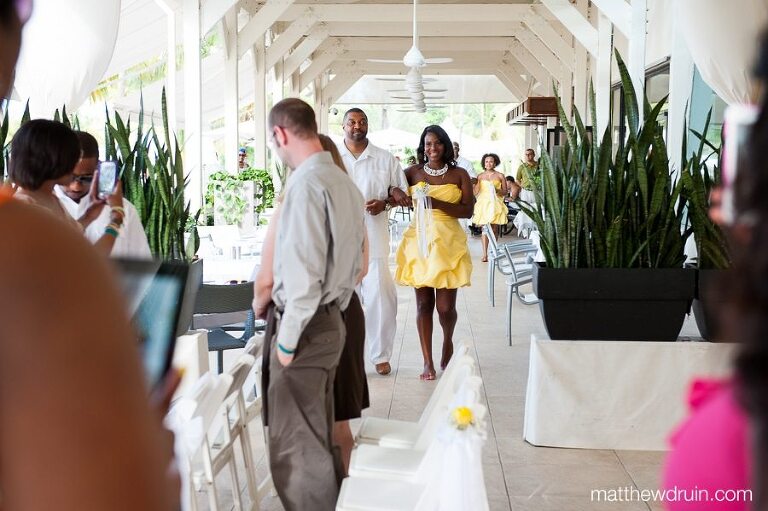 bridesmaids wearing yellow dresses walking down aisle for Puerto Rico wedding ceremony 