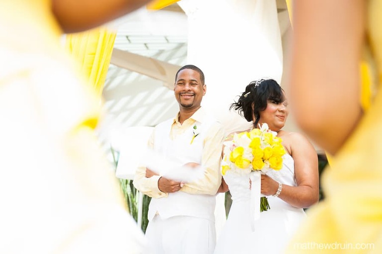Bride and groom with yellow rose bouquet smiling and holding each other at Puerto Rico wedding ceremony   