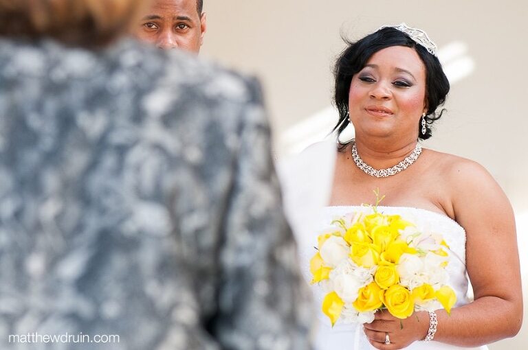 Bride and groom looking at officiant shot from the beach at Puerto Rico wedding ceremony  