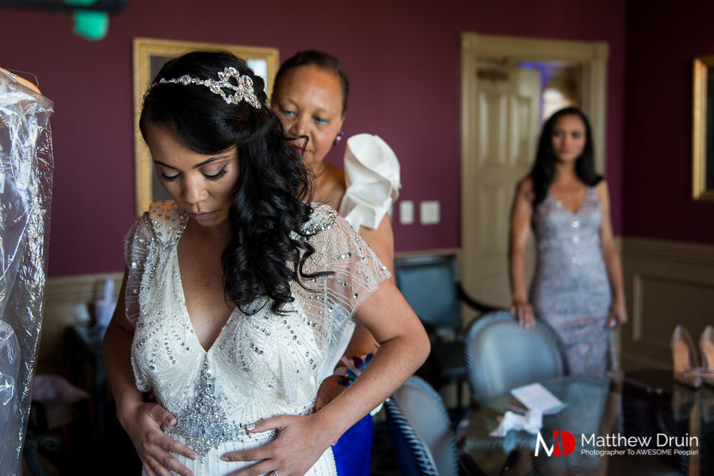 Bride putting on wedding dress at The Peachtree Club wedding