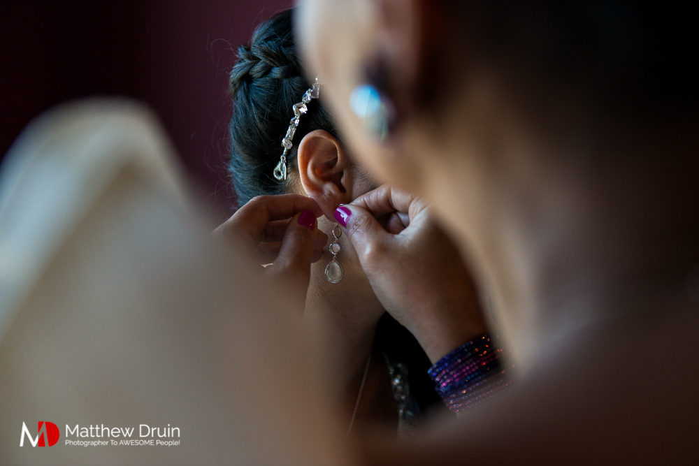 Bridesmaid putting on bride's earrings at The Peachtree Club wedding