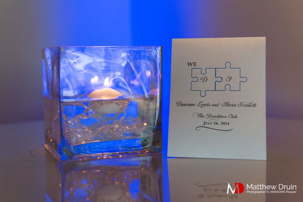 Candles and place cards with blue uplighting at The Peachtree Club wedding reception