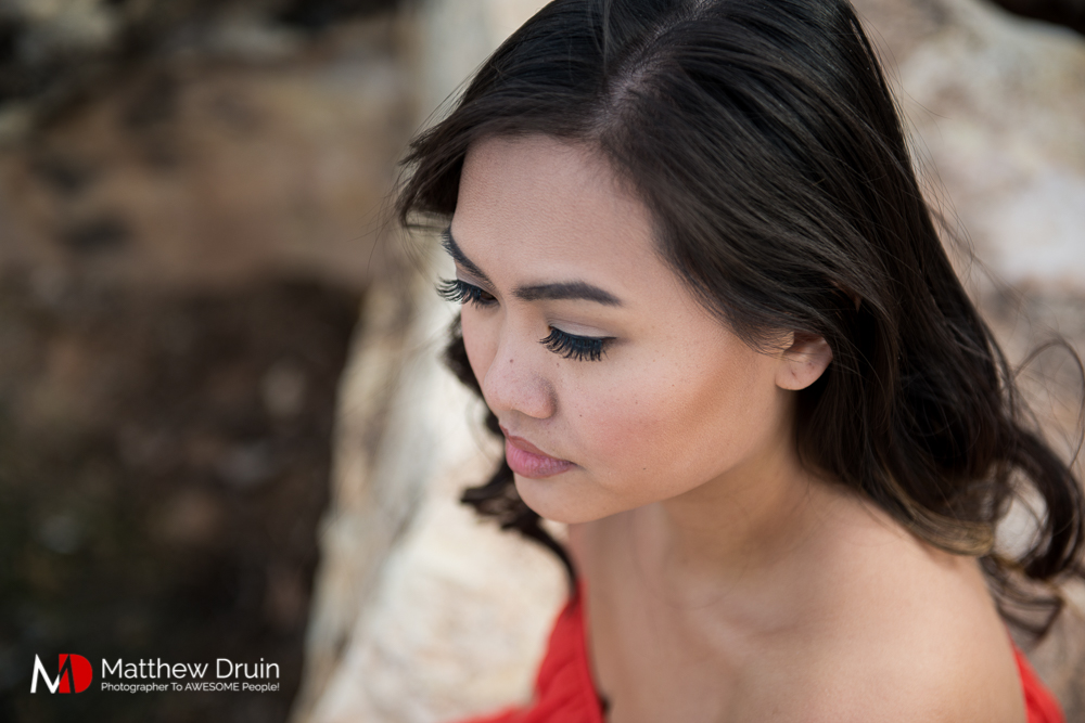 Girl sitting on rocks in Las Vegas desert in red dress