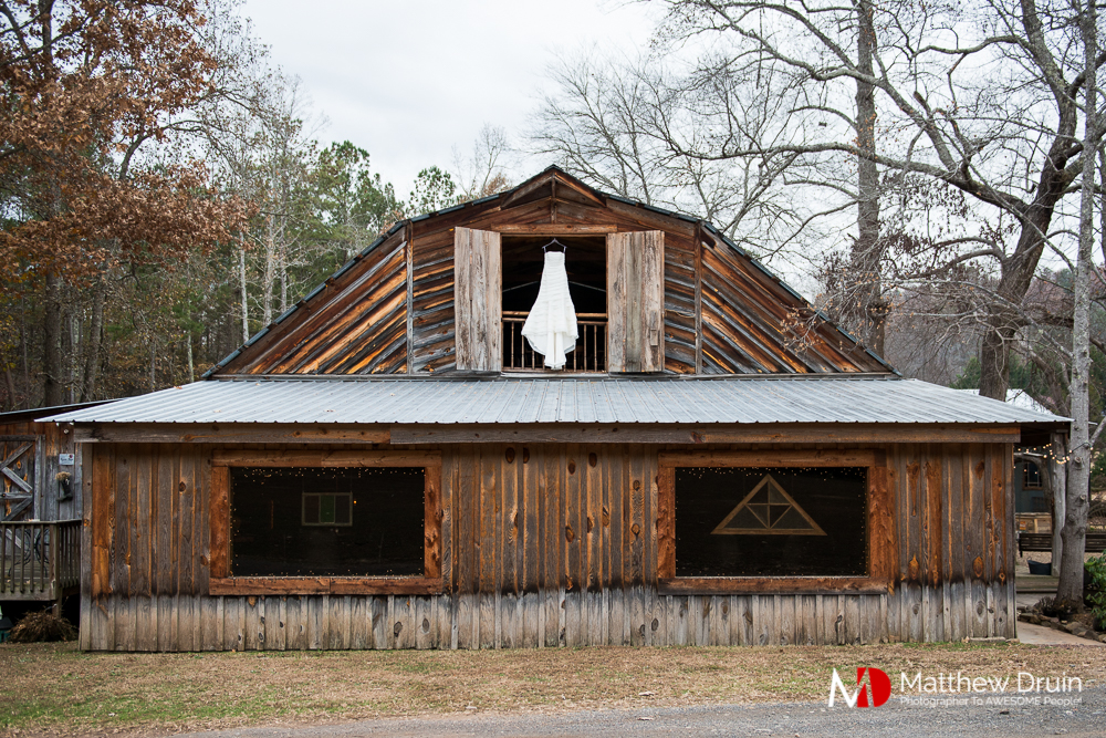 Bride's wedding dress hanging in barn window at Atlanta Wedding Venue Proctor Farm In Georgia Review