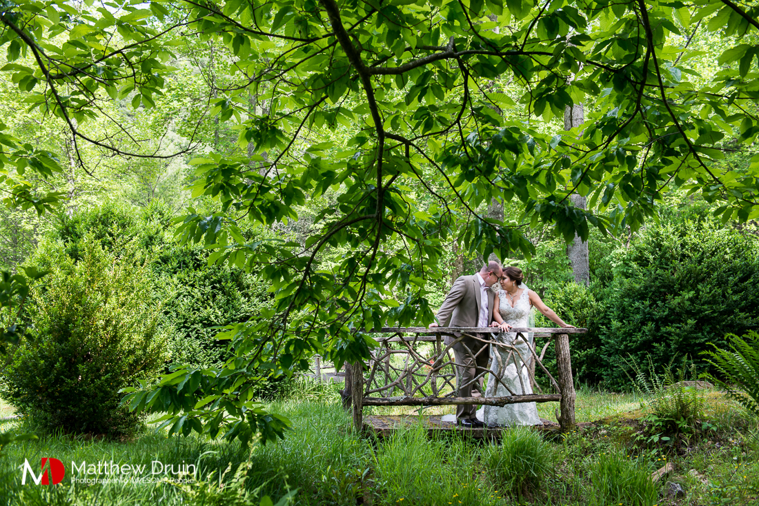 Bride and groom kissing on bridge at vintage wedding at The Cellar at Betty Creek from Atlanta Wedding Photographers Matthew Druin + Co Photography.